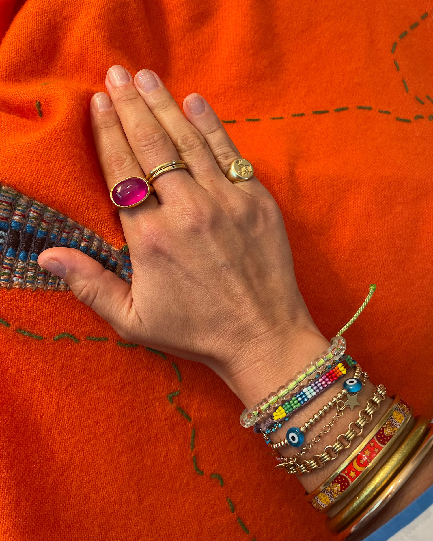 RAM London ruby ring on Victoria Lampley Beren's hand on orange Debbonaire shawl