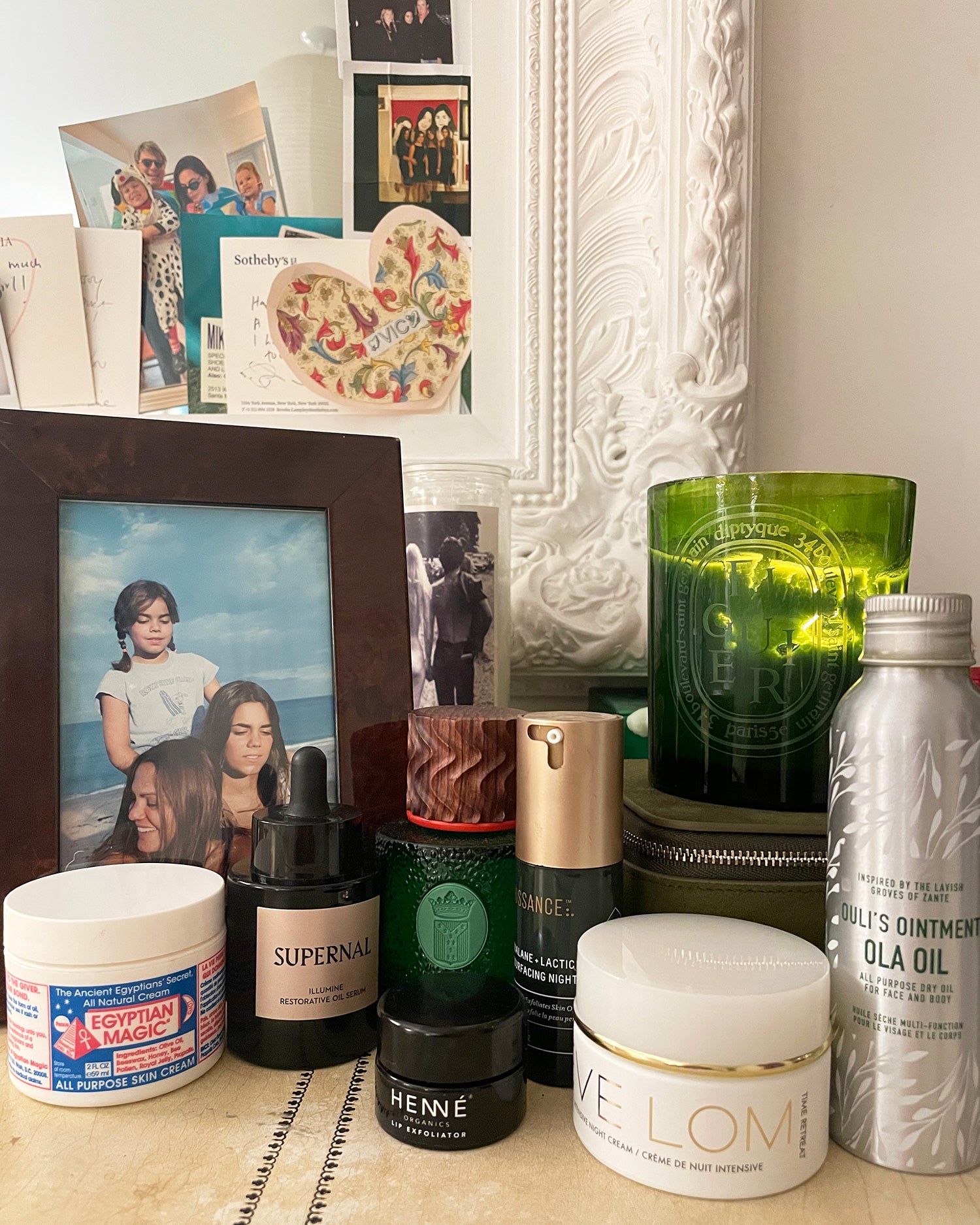 various skincare products and family photos on a dresser 